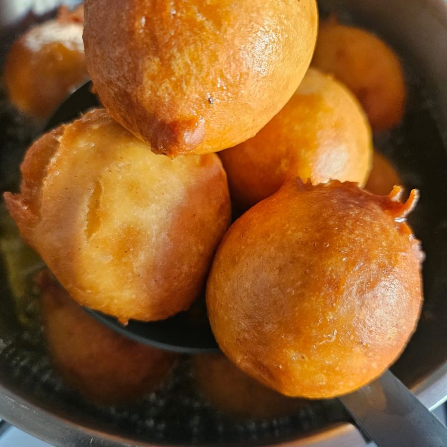 Freshly fried puff puff lifted from the pan
