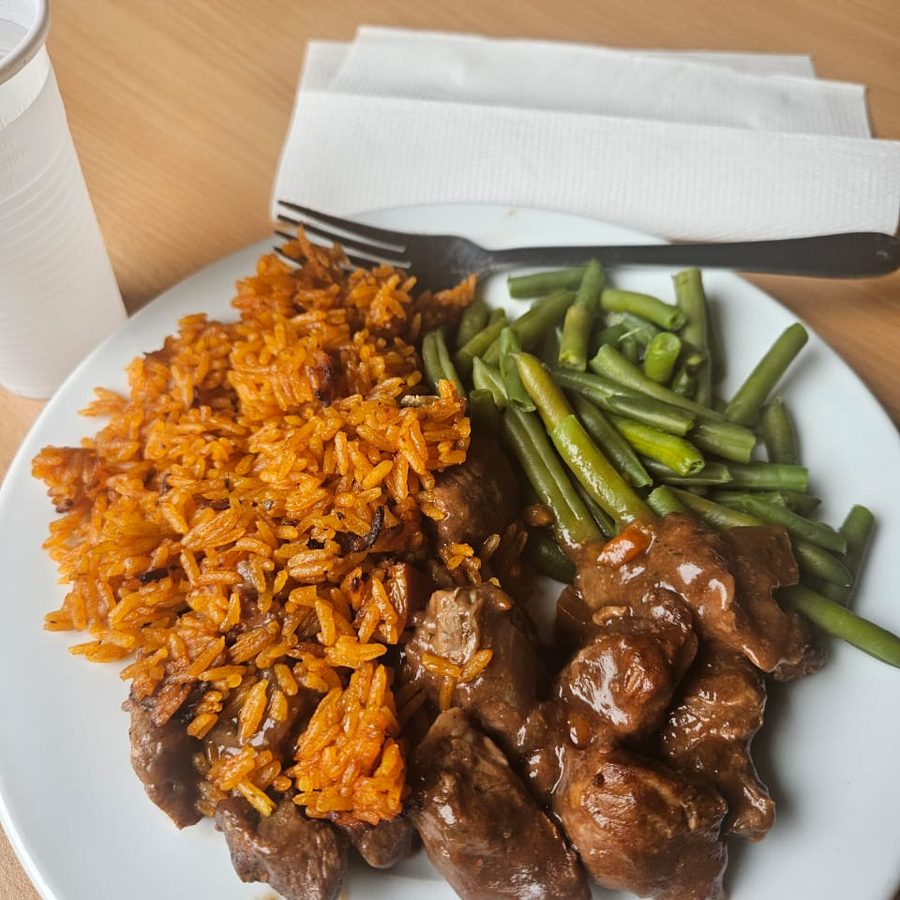 Jollof rice plated with beef and green beans