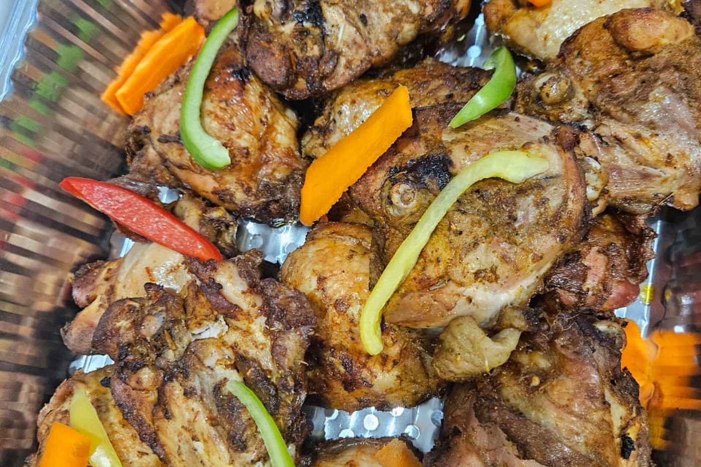 A tray of marinated grilled chicken with peppers