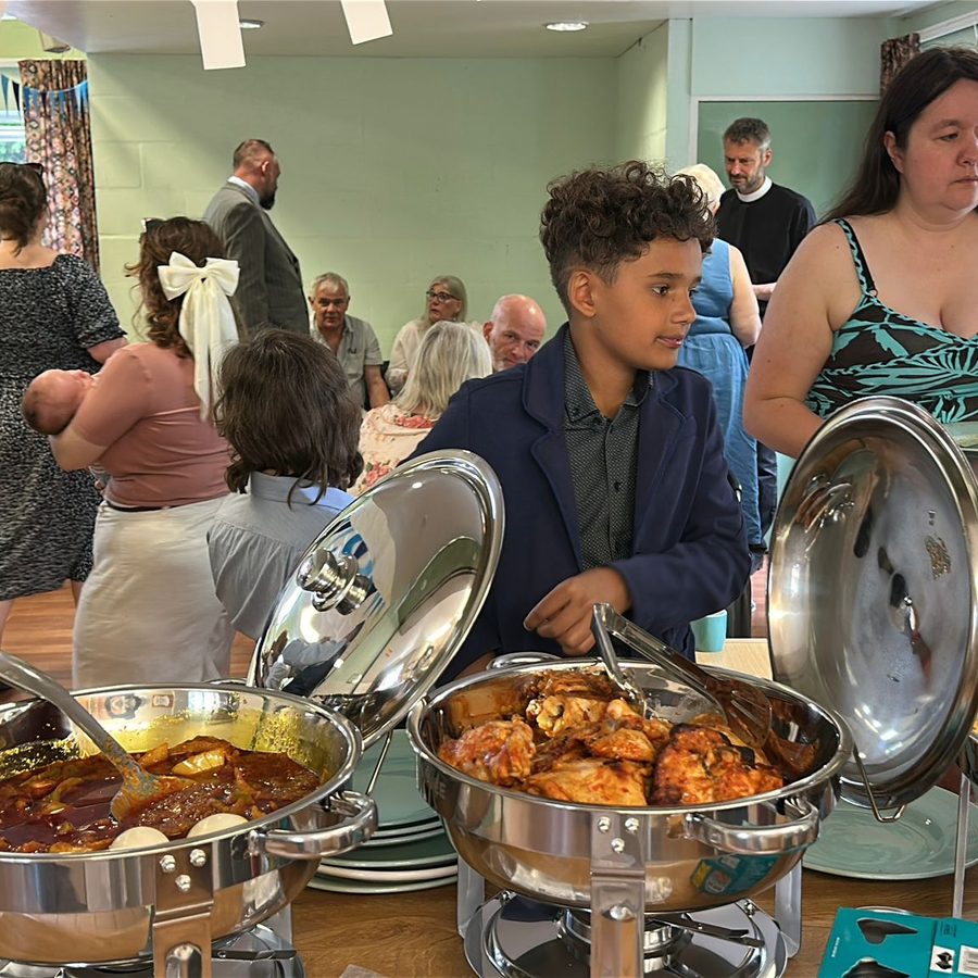 A celebration buffet of stew, grilled chicken and jollof rice served to guests